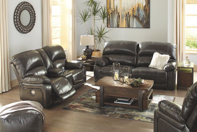 view of a modern living room with a black leather sofa, black leather loveseat, black leather chair, and wooden coffee table 