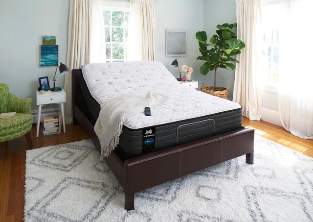 view of a bedroom with light blue walls, white and green accents, and a mattress on an adjustable bed base