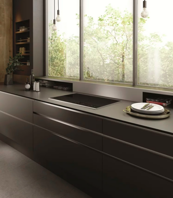 Elegant modern kitchen with a cooktop installed in a countertop facing a window