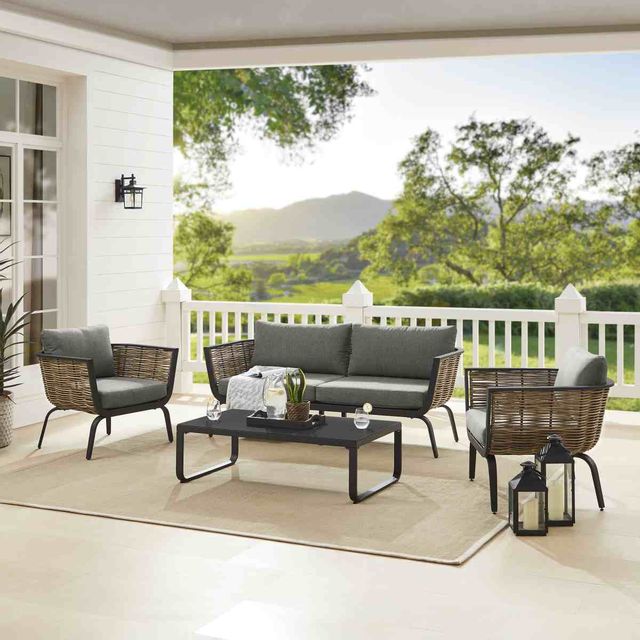 Front right view of a modern outdoor sofa and matching chairs on a porch 