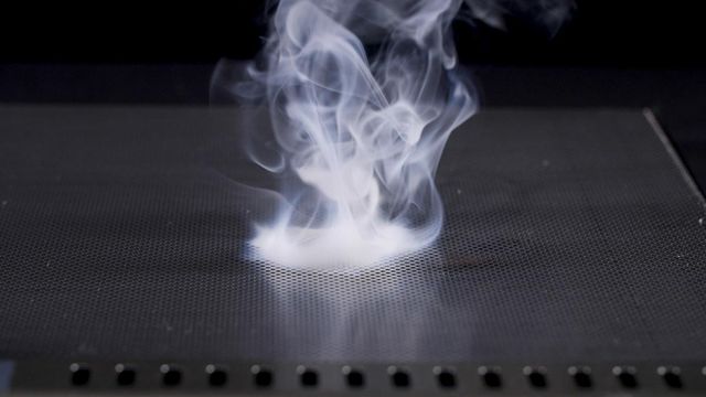 front view of a blaze grill top with a burst of smoke in the center 