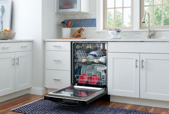 front view of an opened dishwasher in a modern white kitchen