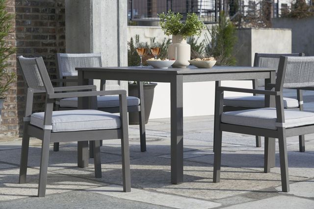 front view of a modern outdoor dining area with a grey table with four seats around it