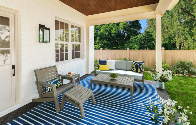 front view of an outdoor sofa, chair, and coffee table sitting on a covered porch