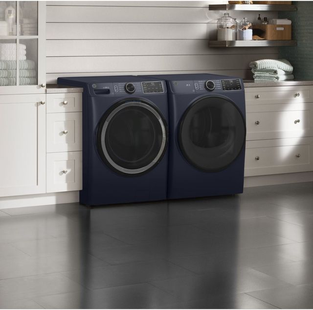 navy blue washer and dryer in a white laundry room