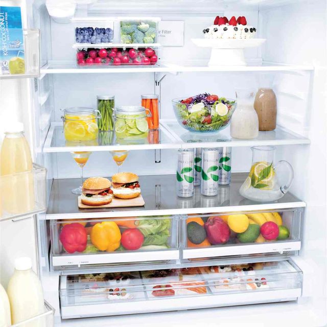 front view of the inside of a french door refrigerator with various foods and drinks inside