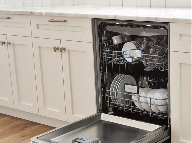 view of an opened viking dishwasher in white cabinetry