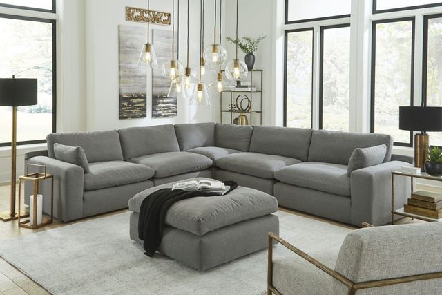 front view of a modern living room with a modern grey l-shaped sectional and matching ottoman with gold accent lamps
