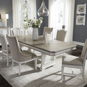 view of the Liberty Abbey Park 7-Piece Antique White Trestle Table Set in a modern dining room with grey walls 
