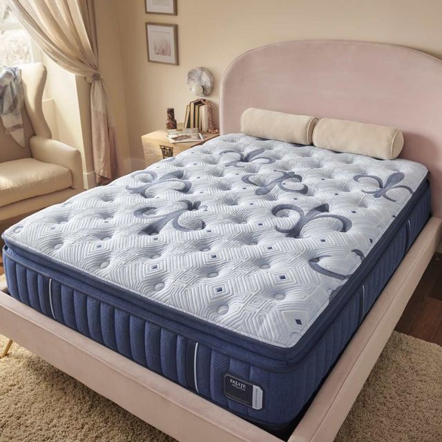 standing view of a pillow top mattress from it's corner. the mattress is in a modern bedroom and is a stearns and foster mattress. 