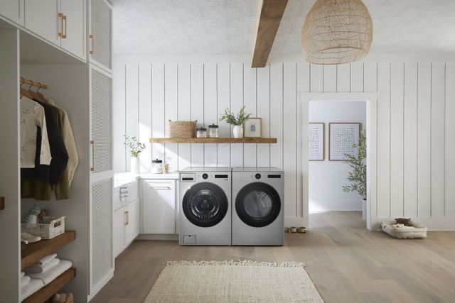 front view of a modern minimal white laundry room with wood accents and a silver LG washer and dryer