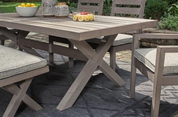 front view of a modern outdoor dining table with lemons, lemon cake, and decor on top