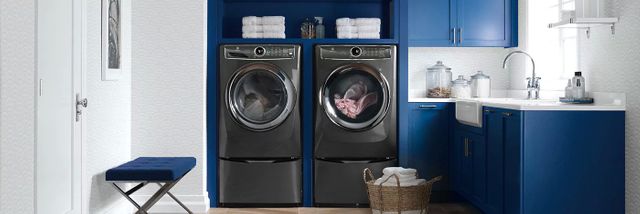 grey washer and dryer in a blue and white laundry room