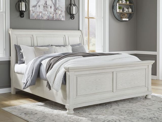 front left view of a white wooden sleigh bed in a modern bedroom with grey walls