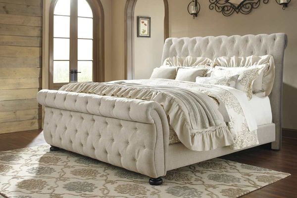 Bedroom featuring a Signature Design by Ashley Willenburg Linen Queen Upholstered Sleigh Bed