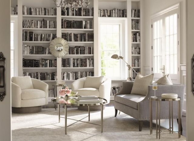 front view of a contemporary living room with two white swivel chairs in the back and a grey couch on the right