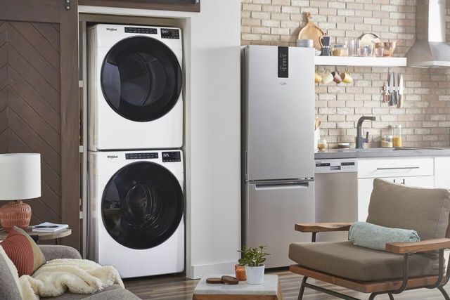 whirlpool washer and dryer in a modern laundry room with sink and towels