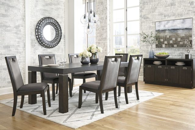 front view of a contemporary dining room with a large black wooden rectangular table, matching chairs, a matching sideboard, and black and white accents throughout