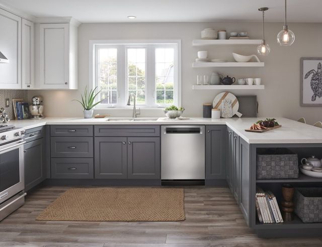front view of a modern kitchen with a stainless steel kitchenaid dishwasher built into grey cabinetry