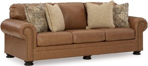 front left view of a brown leather sofa with two beige pillows and two patterned beige pillows