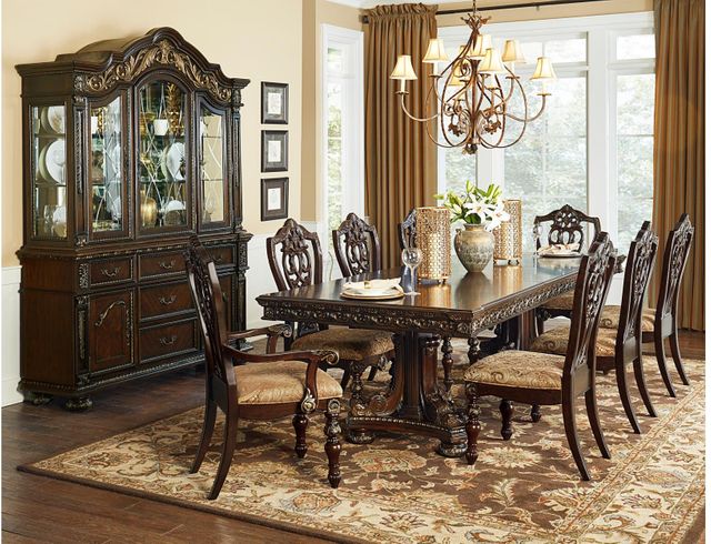 view of a traditional style dining room with a large pedestal table and marching upholstered seats, with a matching sideboard