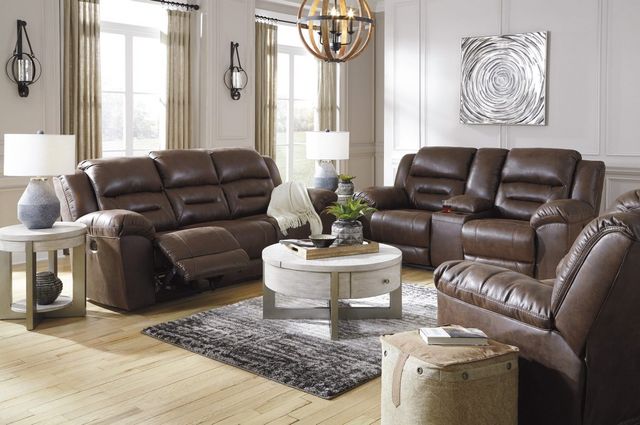 view of a modern living room with a leather reclining sofa and loveseat, round coffee and end tables, and various modern home decor