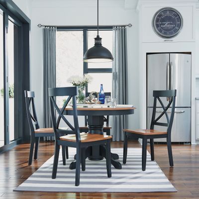 homestyles black and wood round pedestal dining table and chairs in a modern dining space