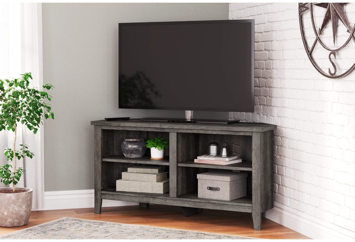 A rustic corner TV stand with a large TV on it