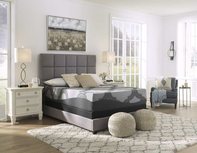front view of a sierra sleep mattress in a box on a grey bed frame in a modern white bedroom