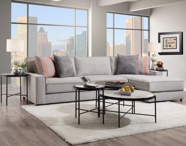 where-to-buy-sofas front standing view of a modern living room with a grey chaise sofa and coffee table, with two large widows showing a city in the background