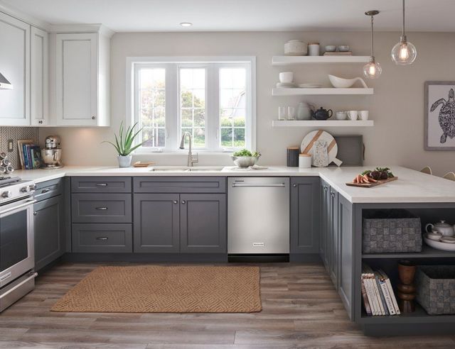 front view of a modern kitchen with light blue cabinets and a stainless steel dishwasher