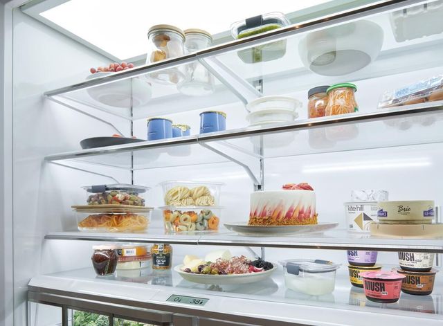 close view of the inside of a large sub-zero refrigerator with various foods on the shelves