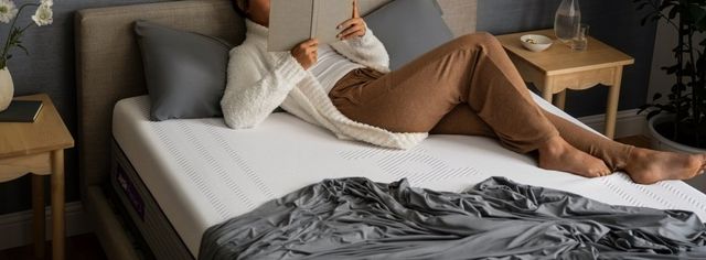 view of a person reading on a purple mattress