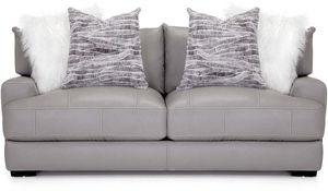 front view of a gray leather two-seat sofa with two white fur pillow and two gray patterned pillows.