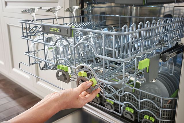 close view of a cove dishwasher rack being pulled out and containing four wine glasses