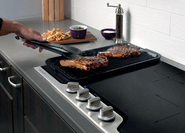 close view of a man cooking meat on an electric cooktop