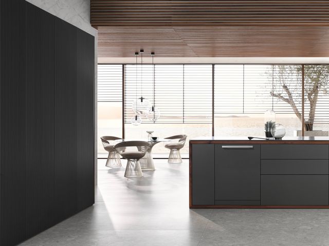 view of a modern kitchen with black cabinetry and a custom panel ready dishwasher 