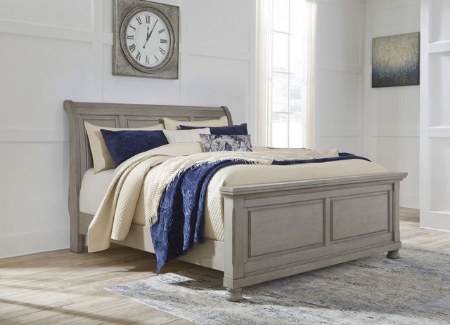 front view of a wooden sleigh bed in a modern bedroom with white walls and navy blue accents