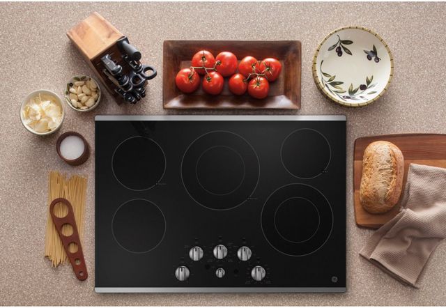 top view of an electric cooktop surrounded by cooking ingredients and utensils