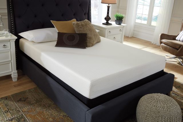 front view of a white mattress from a box on a black upholstered headboard, styled in a modern bedroom