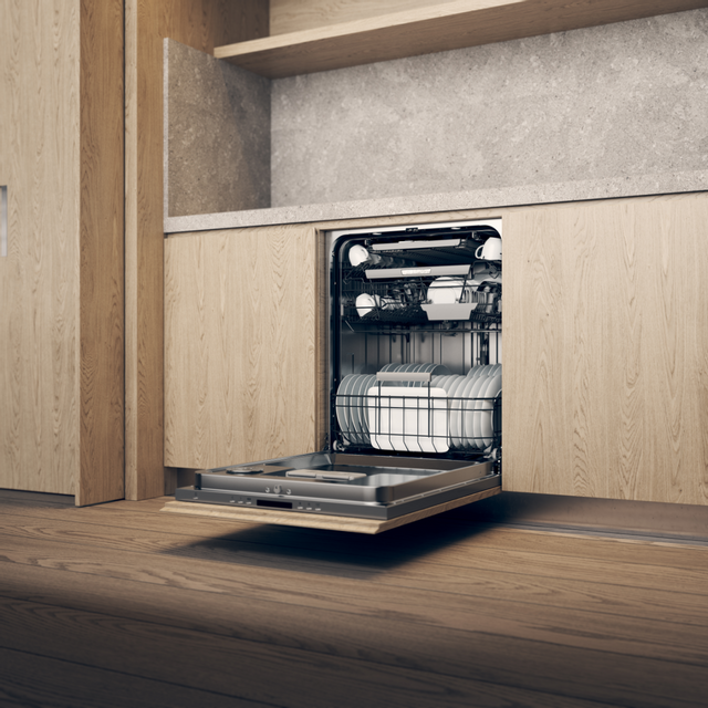 Panel ready ASKO dishwasher with door open in a wood paneled kitchen