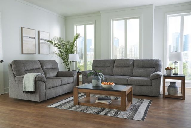 front view of a standard formal living room area with dark gray furniture and light walls