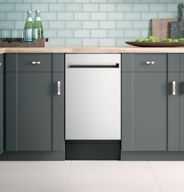 front view of an 18" stainless steel dishwasher built into grey cabinetry in a modern kitchen