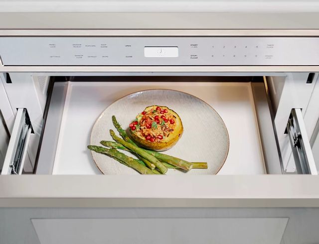 top view of an opened drawer microwave showing reheated asparagus and baked potato