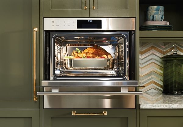 Built into green cabinets, a Wolf oven cooks a turkey