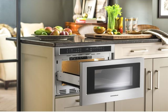 front view of a microwave drawer built into a modern kitchen cabinet with the drawer pulled out