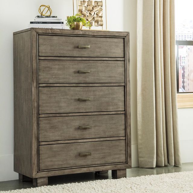 front view of a mid-tone wood chest of drawers styled with books and a plant