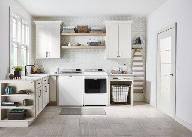 front view of a modern white laundry room with a top load washer and matching dryer
