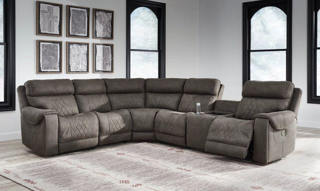 front view of a brown fabric reclining l-shaped sectional with a drink in the cupholder in a modern living room