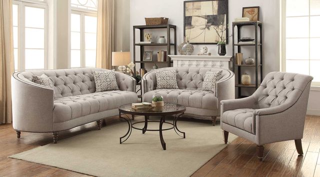 front view of a transitional living room with matching seating, a circular coffee table, and shelving in the background